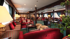 A spacious hotel lobby with multiple seating areas, including sofas and armchairs, arranged around a central coffee table. - JAZ Helio Nile Cruise - Every Monday from Luxor for 07 & 04 Nights - Every Friday From Aswan for 03 Nights (Luxor)