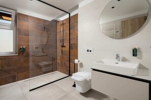 A modern bathroom with a glass shower enclosure, a toilet, a sink, and a mirror. - The Alley by Kanopian (Brasov)