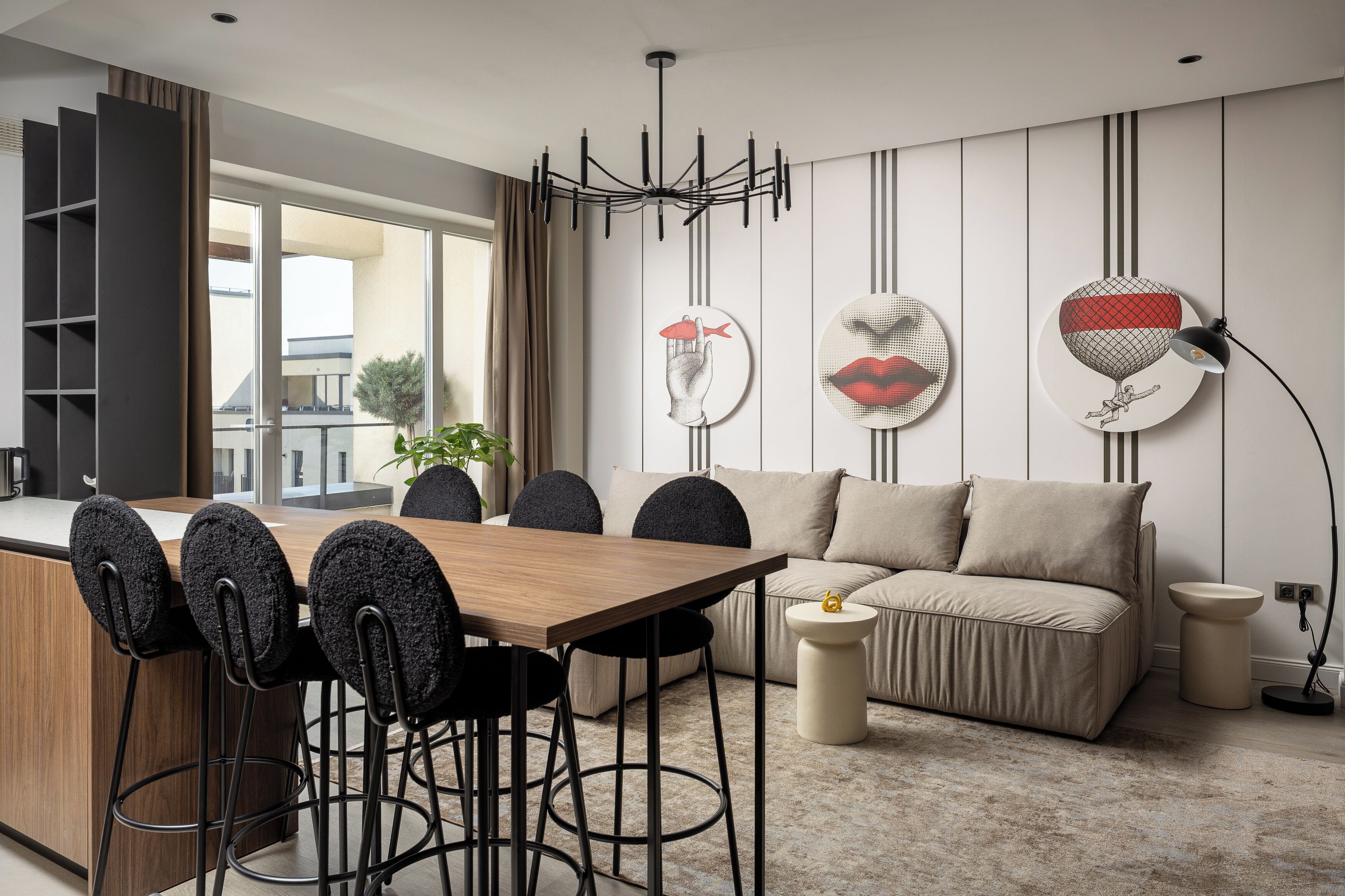 Un soggiorno moderno con un divano, un tavolo da pranzo con sedie e un lampadario.