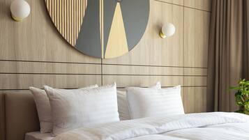 A modern hotel room with a large bed, a wooden headboard, and a wall-mounted abstract artwork.