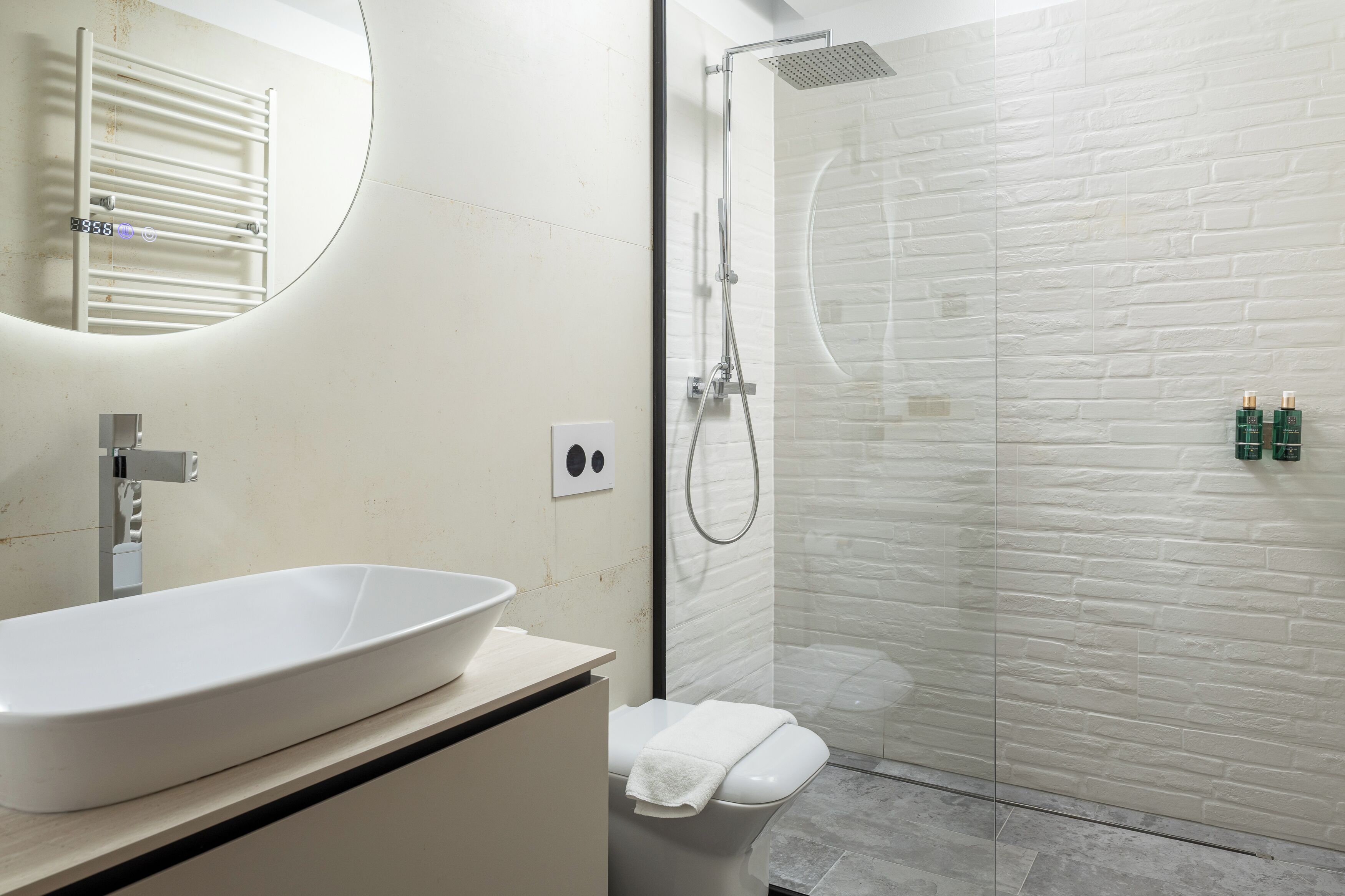 Ein Badezimmer mit einem weißen Waschbecken, einer Toilette und einer Duschkabine aus Glas.