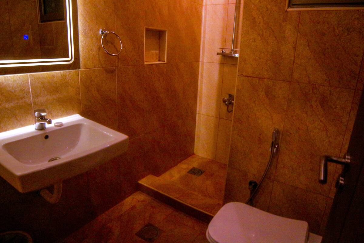 Un baño con lavamanos, inodoro y ducha.