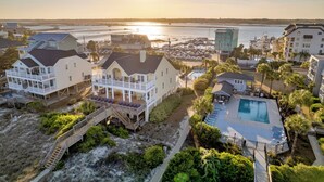 A coastal property with a large deck, a swimming pool, and a view of the water. - Marlin View: Oceanfront w/ Pool, Walk to Dining (Garden City)