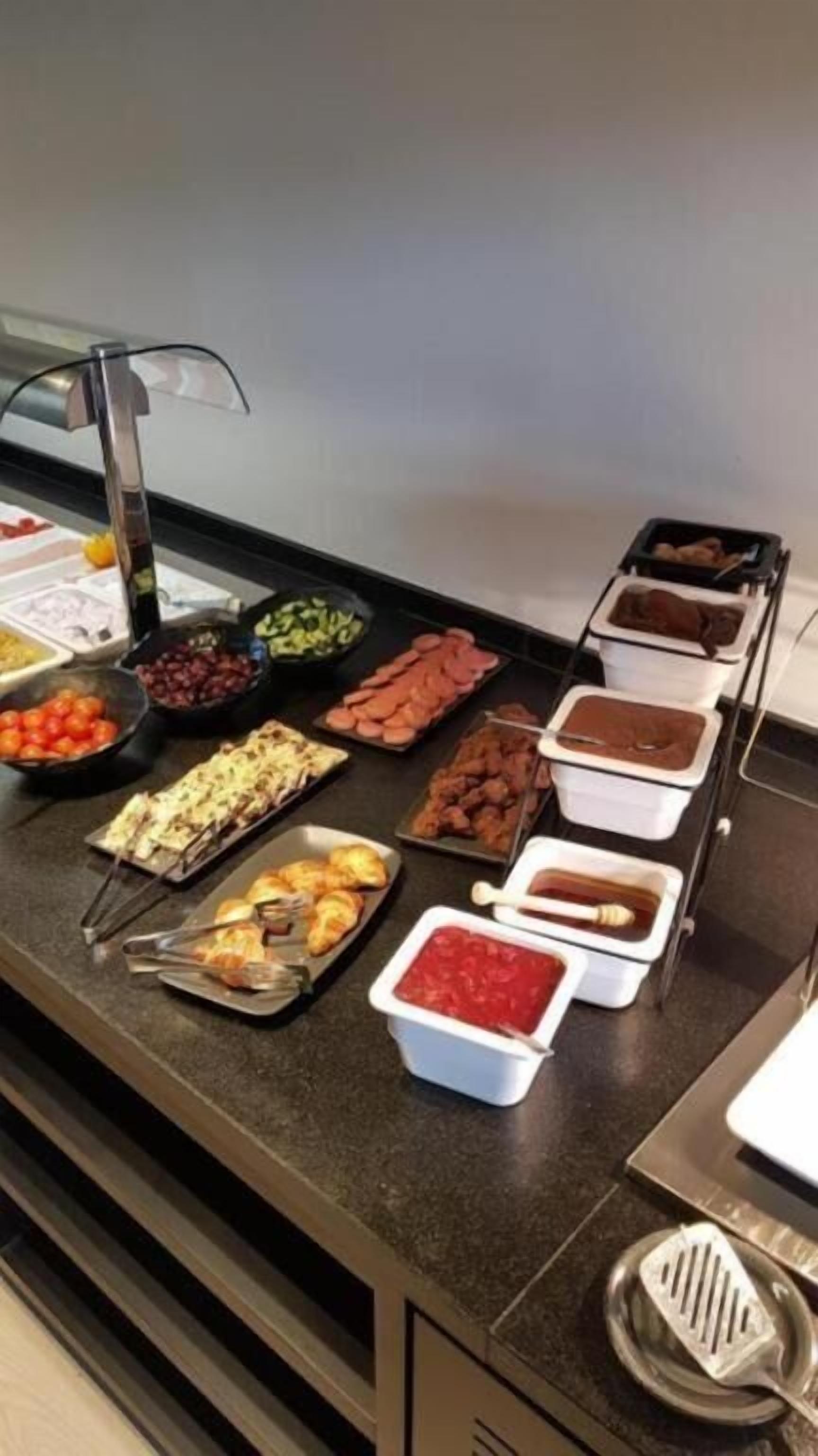 A buffet with various food items including fruits, meats, and dips.