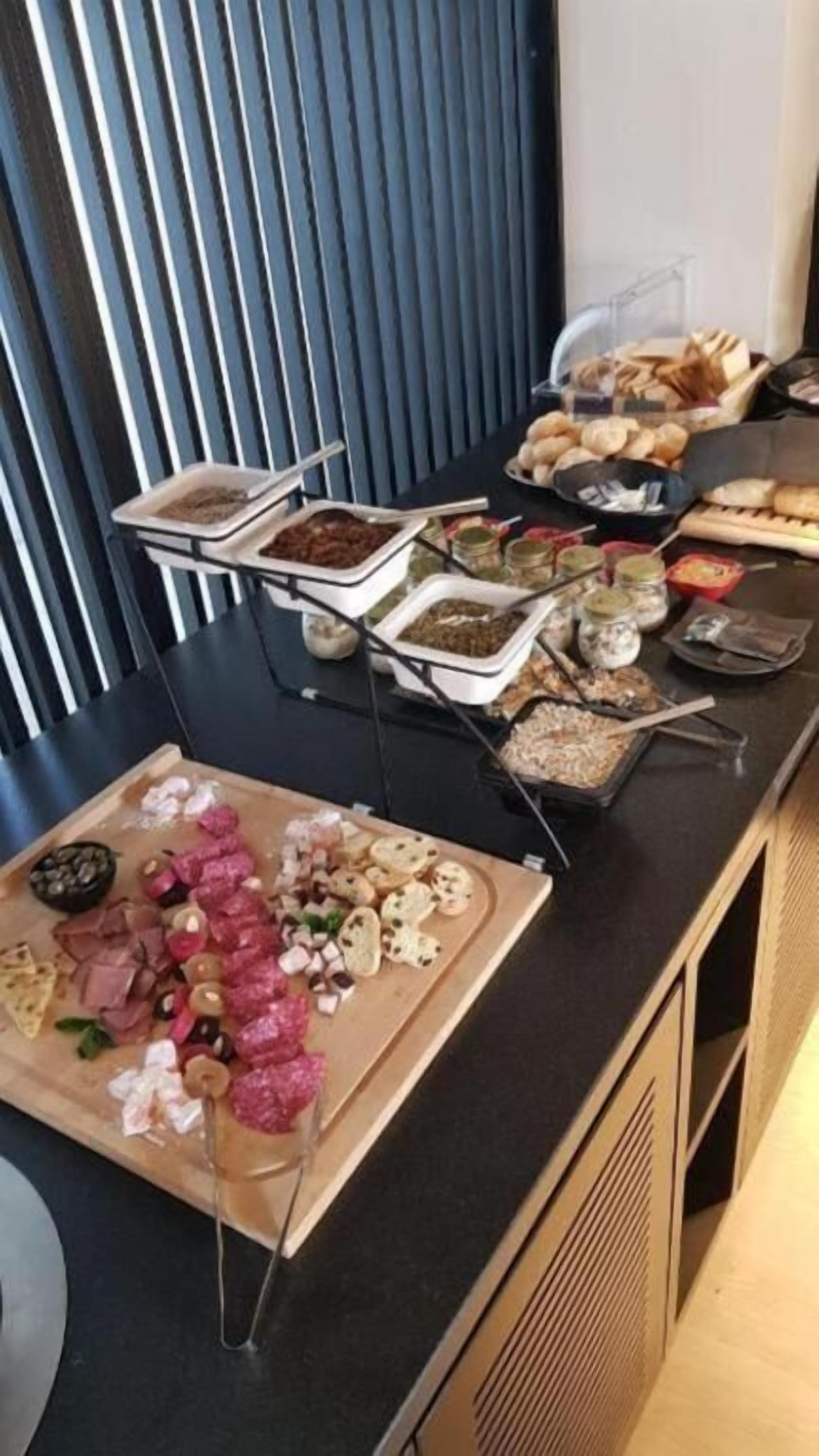 En buffet med forskellige spiser, herunder kød, oste og brød.