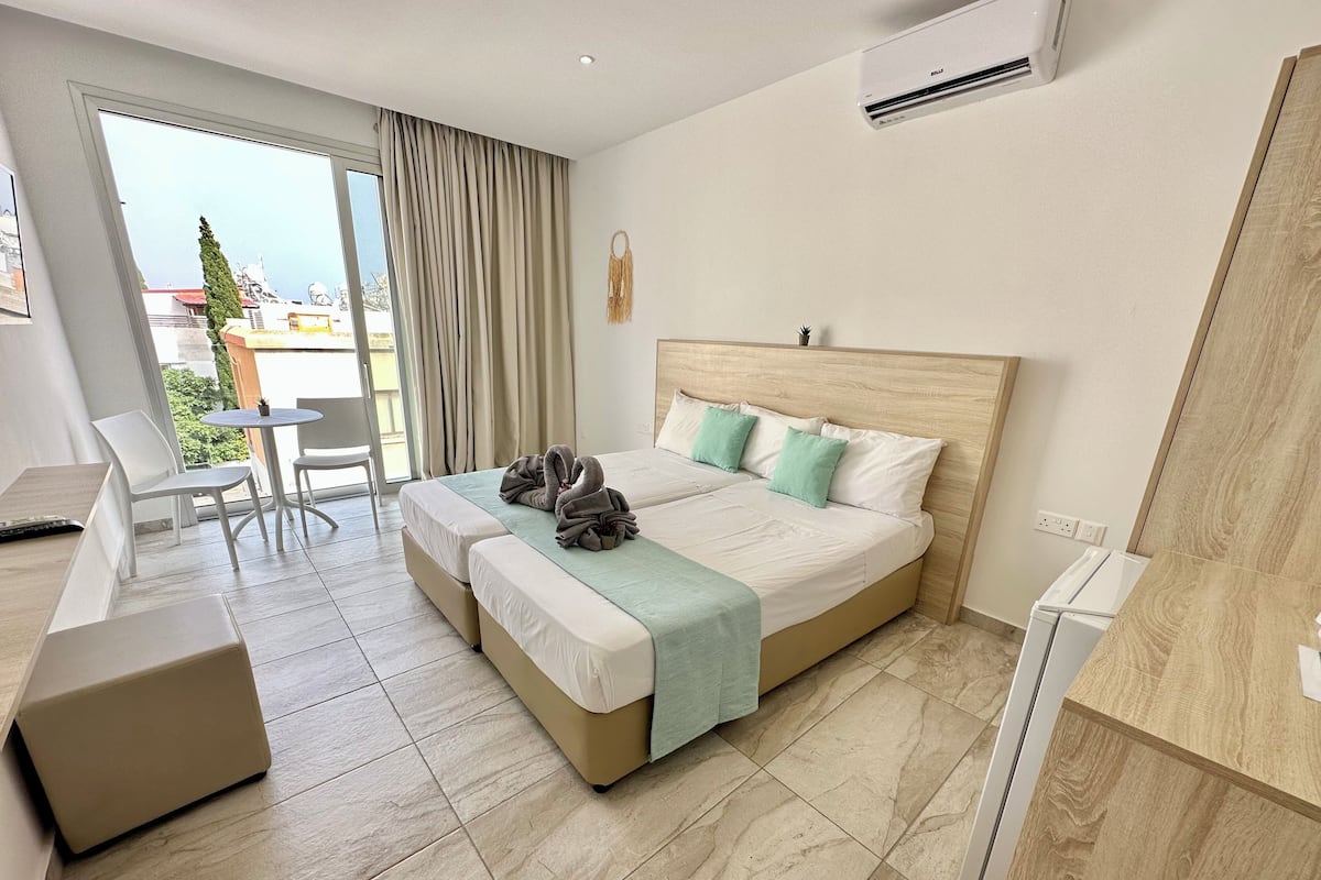 A hotel room with a bed, a desk, and a chair.