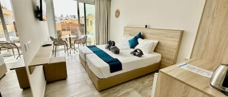 Une chambre d’hôtel avec un lit, un bureau, une chaise et une vue sur la ville.