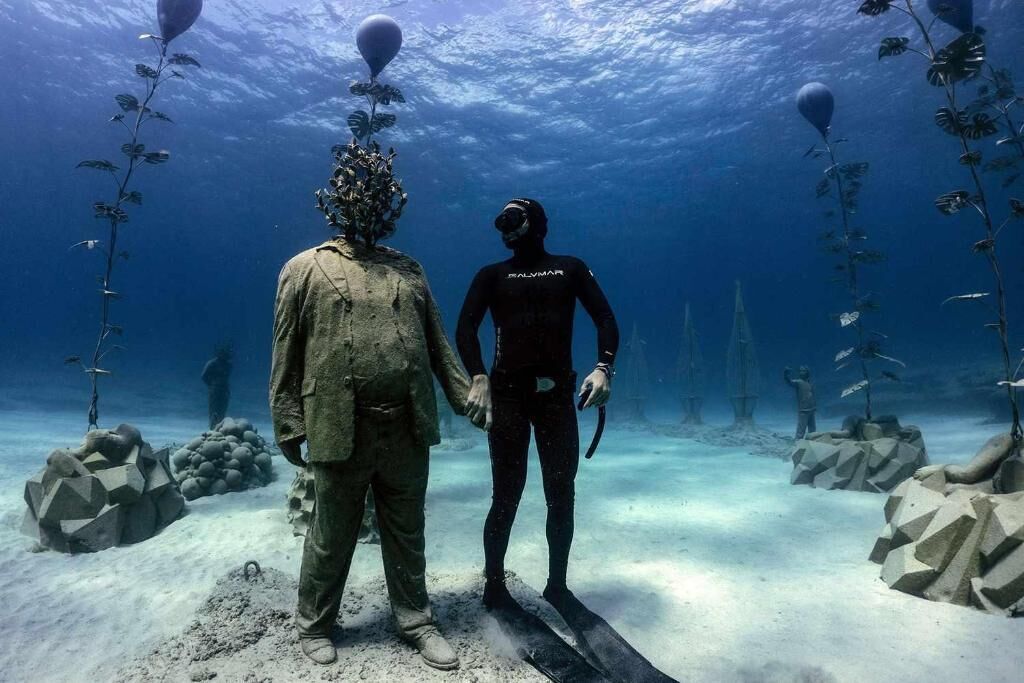 Une scène sous-marine mettant en scène deux plongeurs, l’un portant une combinaison de plongée et l’autre une combinaison de plongée avec un casque.