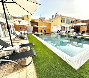 Een seizoensgebonden buitenzwembad en parasols bij het zwembad