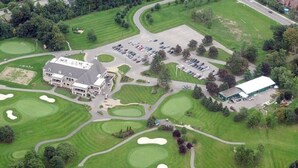 An aerial view of a golf course with a clubhouse, parking area, and a large building. - Sassafras Oasis | Sleeps 14 | All-Season Retreat Near Barrie (Minesing)