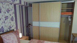 A bedroom with a bed, a wardrobe, a nightstand, and a lamp. - 2 Bedroom Apartment in Bad Marienberg (Westerwald) (Bad Marienberg (Westerwald))