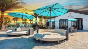 Ein Poolbereich mit Liegestühlen und Sonnenschirmen, ein Barbereich sowie ein Gebäude mit der Beschriftung 'Ti Casa BAR & LOUNGE'.