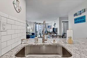 Enjoy cooking in this well-equipped kitchen with a stainless steel sink and marble countertop.