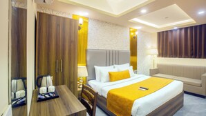 A hotel room with a bed, bedside table, and a seating area. - Mehak Palace (Noida)