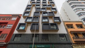 A modern building with multiple balconies and a sign for 'Casa del Libro'.