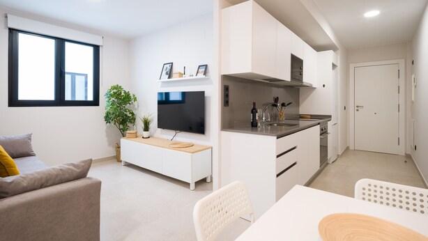 A modern apartment with a living room, dining area, and kitchen.