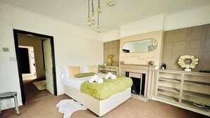 Une chambre à coucher avec un lit, une cheminée, un miroir et une armoire.