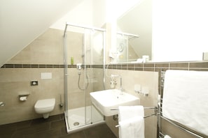 A modern bathroom with a glass shower enclosure, a white sink, and a towel rack. - Amelie Chez Inez (Radolfzell am Bodensee)