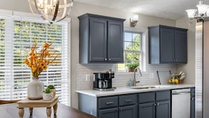 A modern kitchen with dark cabinets, a white countertop, and a coffee maker. - Burgess Falls bungalow minutes from Cookeville (Sparta)