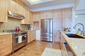 Una cocina moderna con armarios de madera, electrodomésticos de acero inoxidable y encimera de granito.