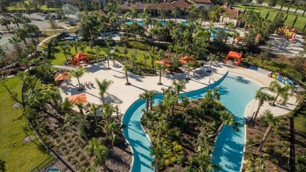 An aerial view of a resort with a large swimming pool, palm trees, and multiple buildings. - Gated Luxury Resort Home With South Facing Pool (Davenport)