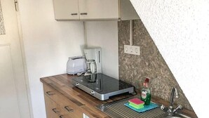 A compact kitchen with a wooden countertop, a built-in dishwasher, a sink, and a coffee maker. - 2 Bedroom Apartment in Bad Marienberg (Westerwald) (Bad Marienberg (Westerwald))