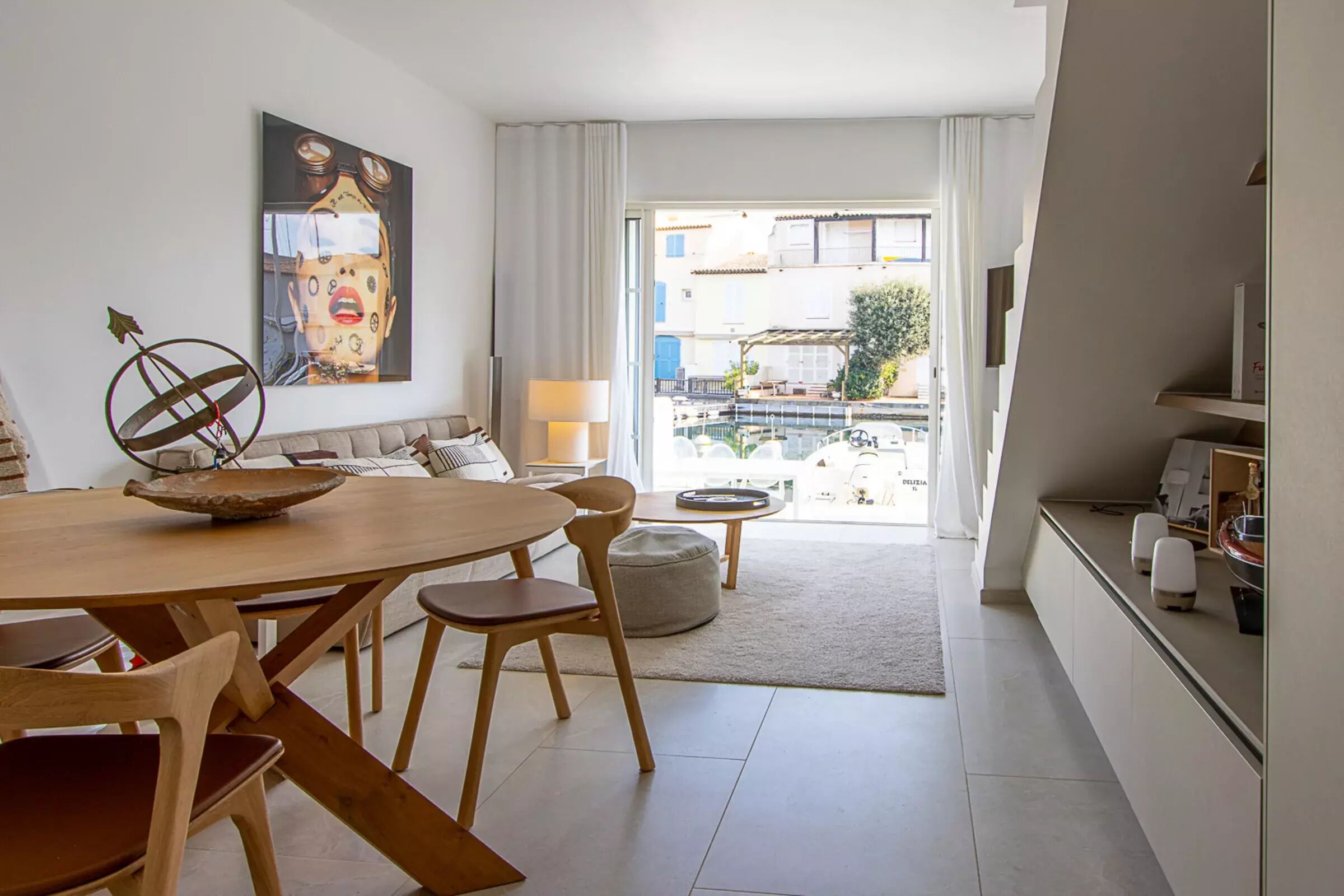 Ein modernes Wohnzimmer mit Essbereich, einem großen Fenster und Blick ins Freie.