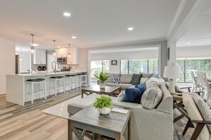 A spacious living area with a kitchen, a large sofa set, and a dining table. - Spacious Lake Norman Retreat w/ Boat Ramp! (Sherrills Ford)
