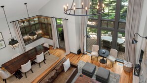 A spacious living area with a large wooden dining table, leather sofas, and a cozy fireplace. - Single family home on Beaver Creek golf course with lots of upgrades!! (Beaver Creek)