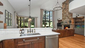 A modern kitchen with a large island, stone fireplace, and large windows. - Single family home on Beaver Creek golf course with lots of upgrades!! (Beaver Creek)