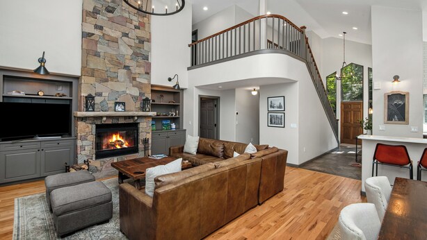 A spacious living room with a stone fireplace, a large sectional sofa, and a wooden coffee table. - Single family home on Beaver Creek golf course with lots of upgrades!! (Beaver Creek)