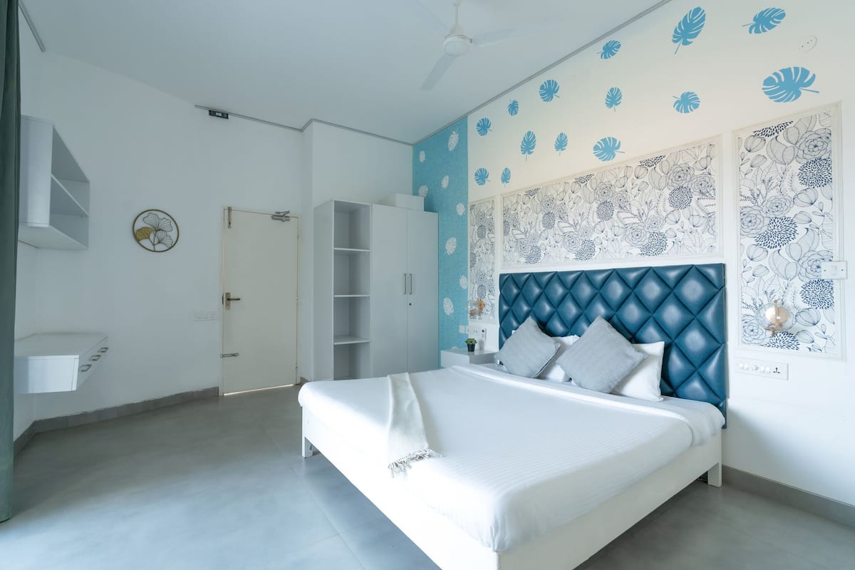 Ein modernes Schlafzimmer mit Bett, Kleiderschrank, Schminktisch und Deckenventilator.