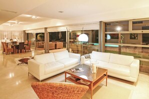 Relax in this stylish living room with a large sofa, coffee table, and dining area.
