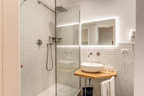 A modern bathroom with a glass-enclosed shower, a white sink, and a mirror above the sink. - La Corte di Partenope (Naples)