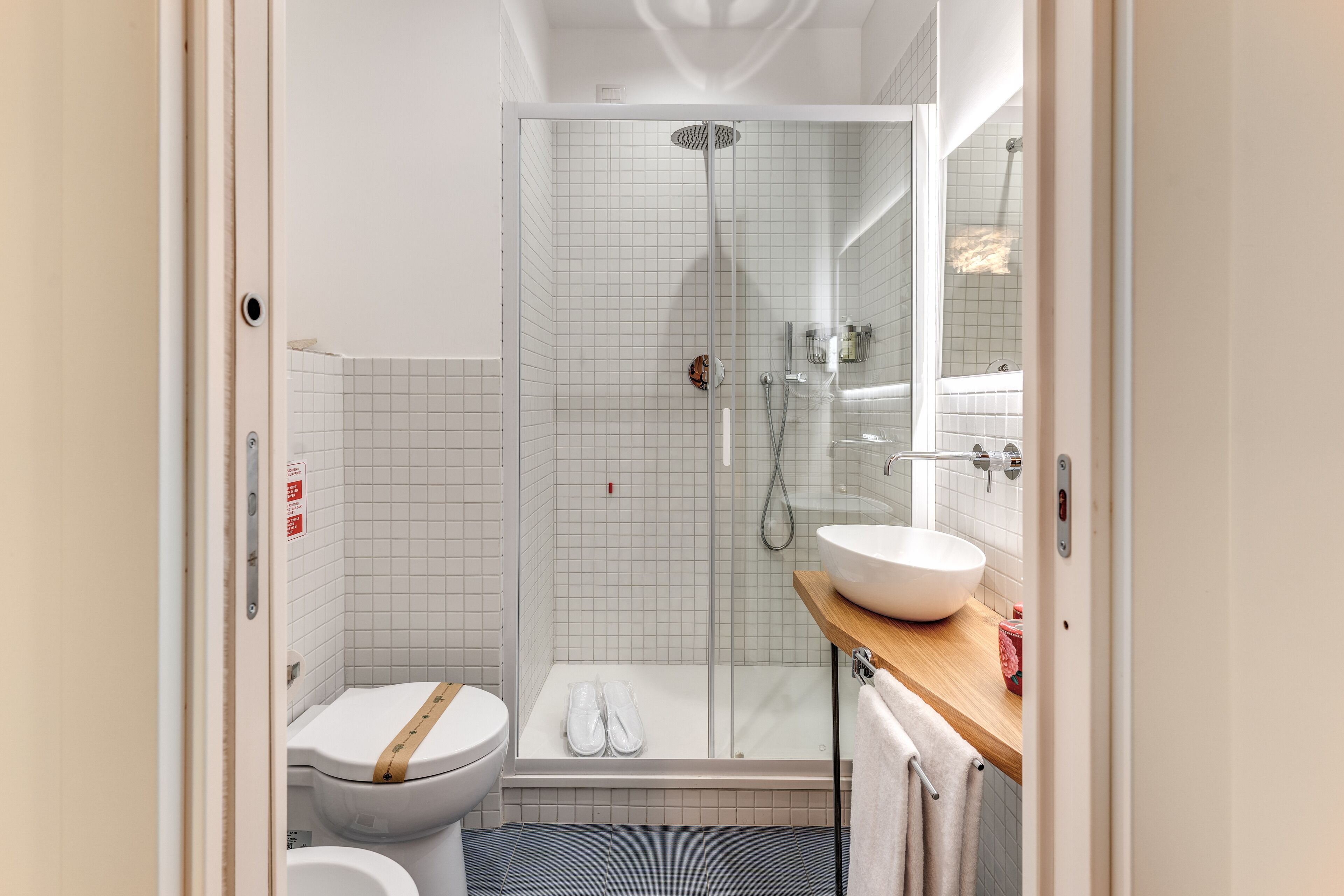 A modern bathroom with a toilet, shower, and sink.