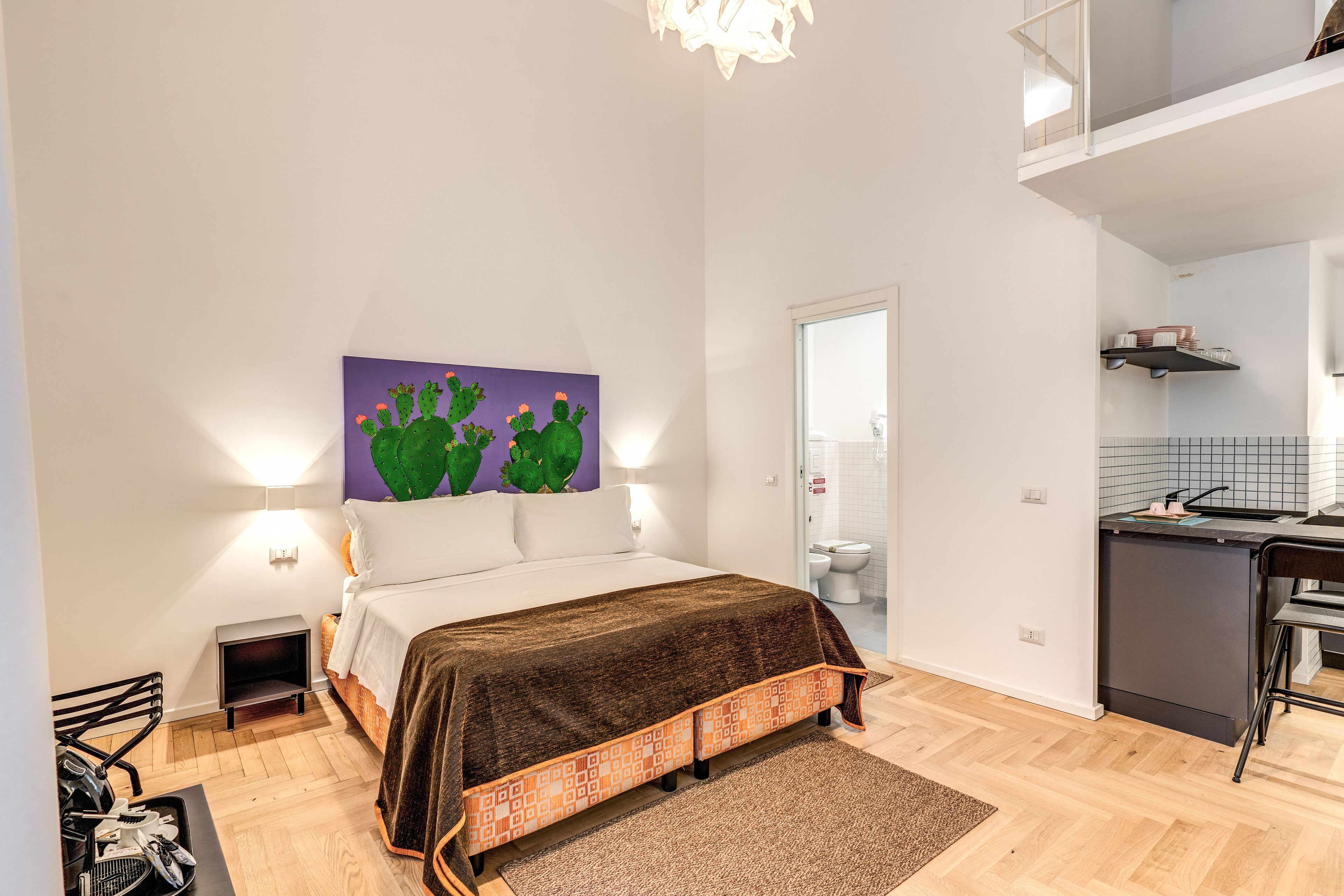 A bedroom with a bed, a nightstand, a desk, and a chair.