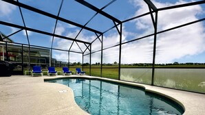 A swimming pool with a curved edge, surrounded by a covered area with blue chairs. - Convenient to Restaurants, Pool, Golf Views (Davenport)