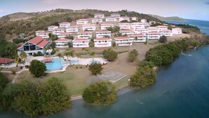 An aerial view of a coastal resort with multiple white buildings, a swimming pool, and a beach area. - Private Ocean Front Via Maris Villa with Big Pool @ Culebra, Recently Refreshed! (Culebra)