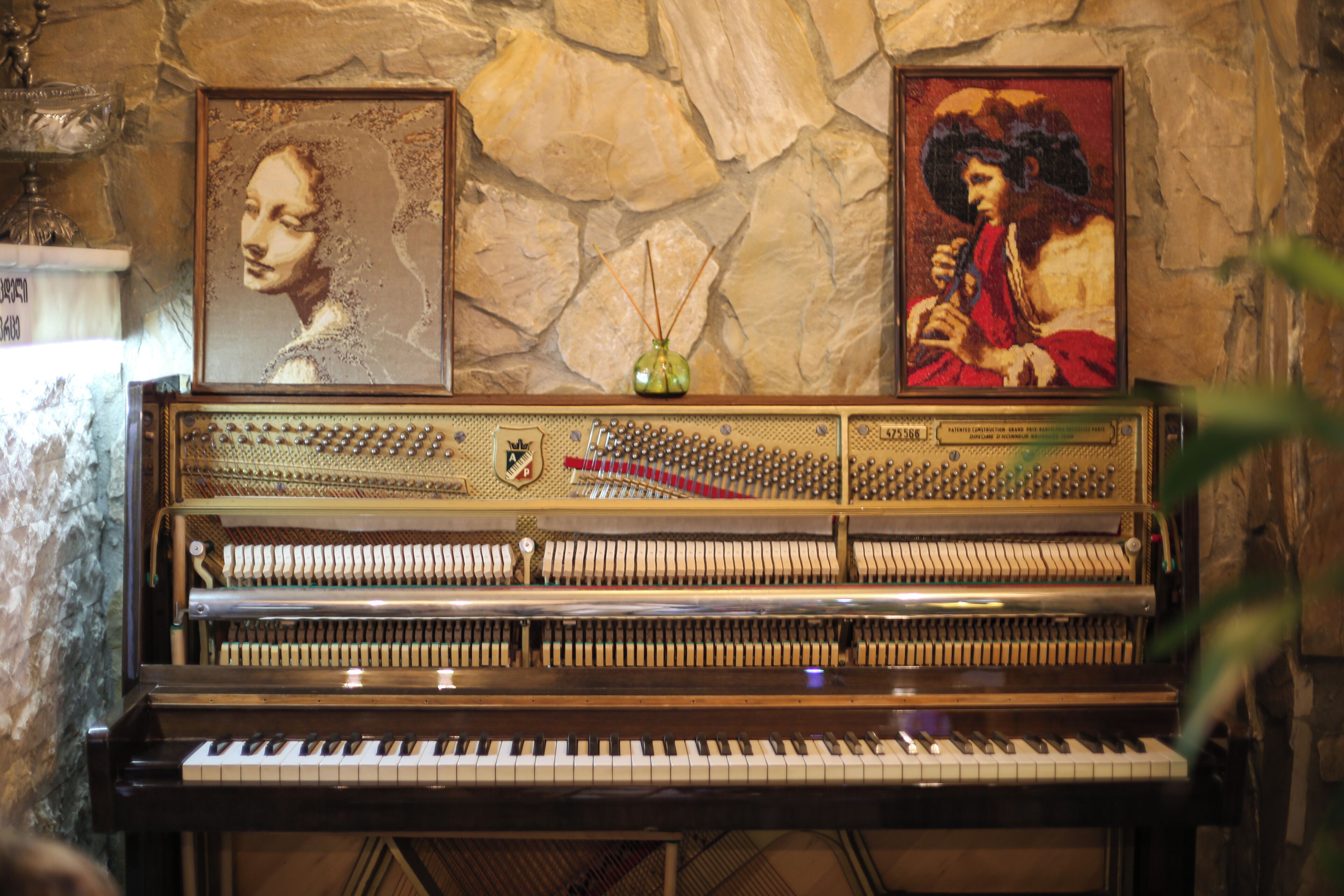 A grand piano with sheet music stands and a decorative vase.