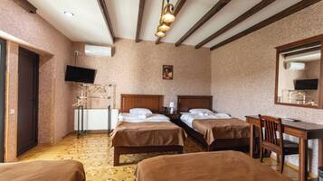 Een hotelkamer met twee bedden, een bureau, een stoel, een televisie en een radiator.