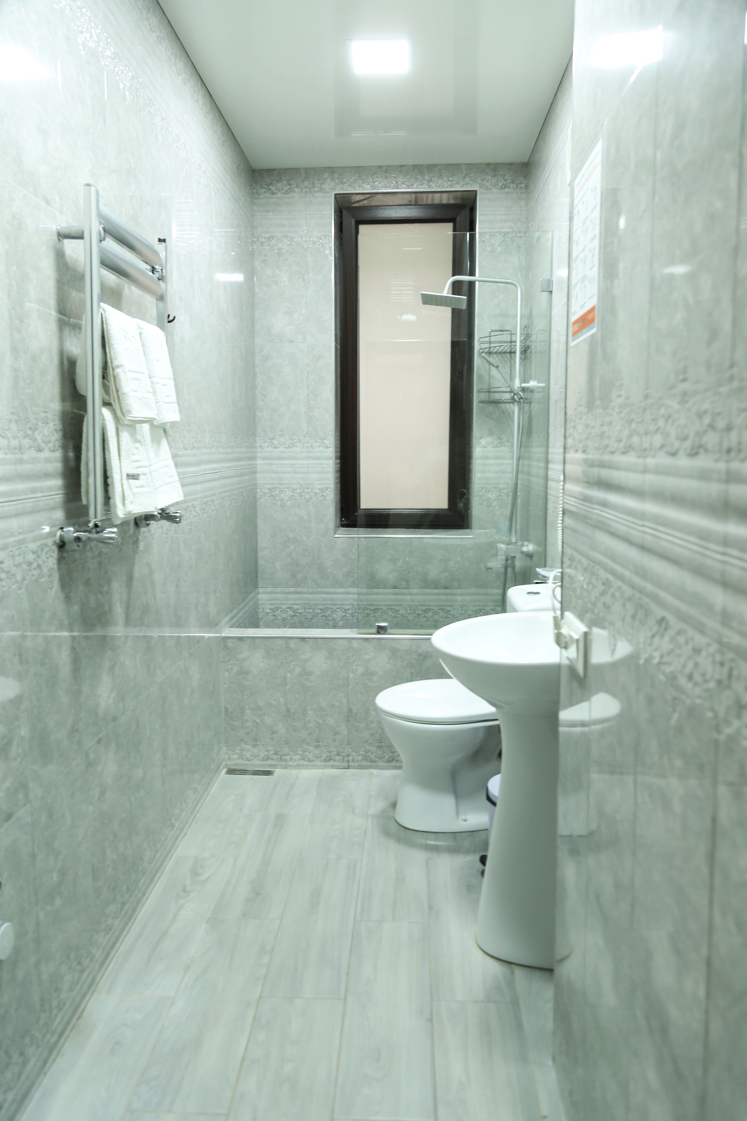 A modern bathroom with a shower, toilet, and sink.