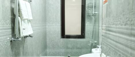 A modern bathroom with a shower, toilet, and sink.
