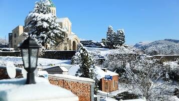 A snow-covered landscape with a church and brick buildings.
