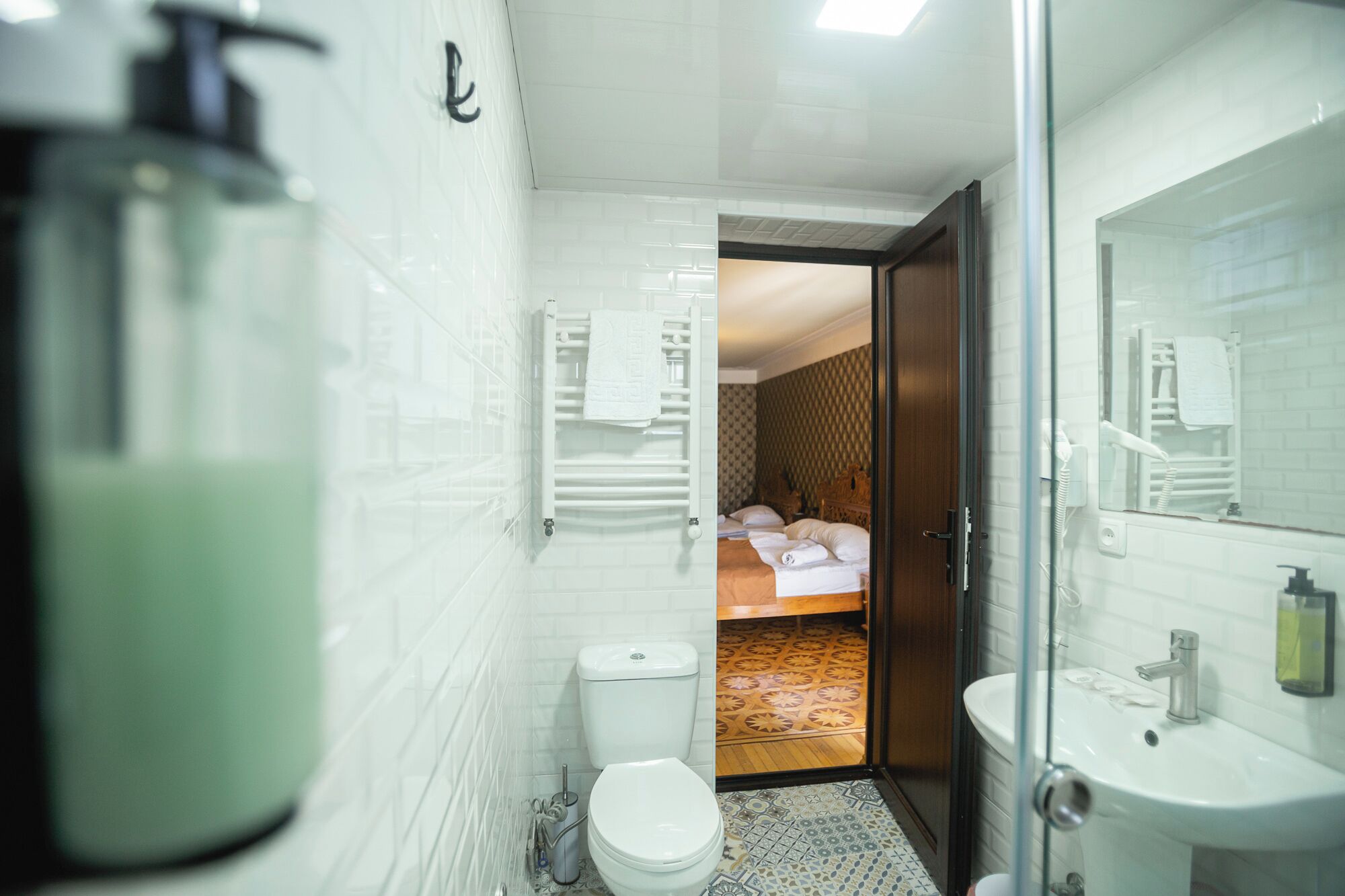 A modern bathroom with a glass shower enclosure, a white sink, and a toilet.
