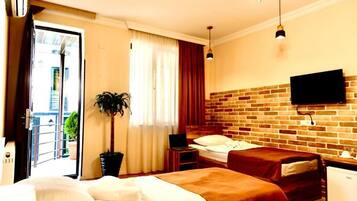 Vierpersoonskamer, Meerdere bedden, terras | Luxe beddengoed, een kluis op de kamer, individueel gedecoreerd