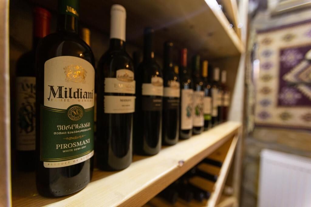 Un porte-bouteilles contenant des bouteilles de vin blanc Pirosmani, un vin demi-sec.