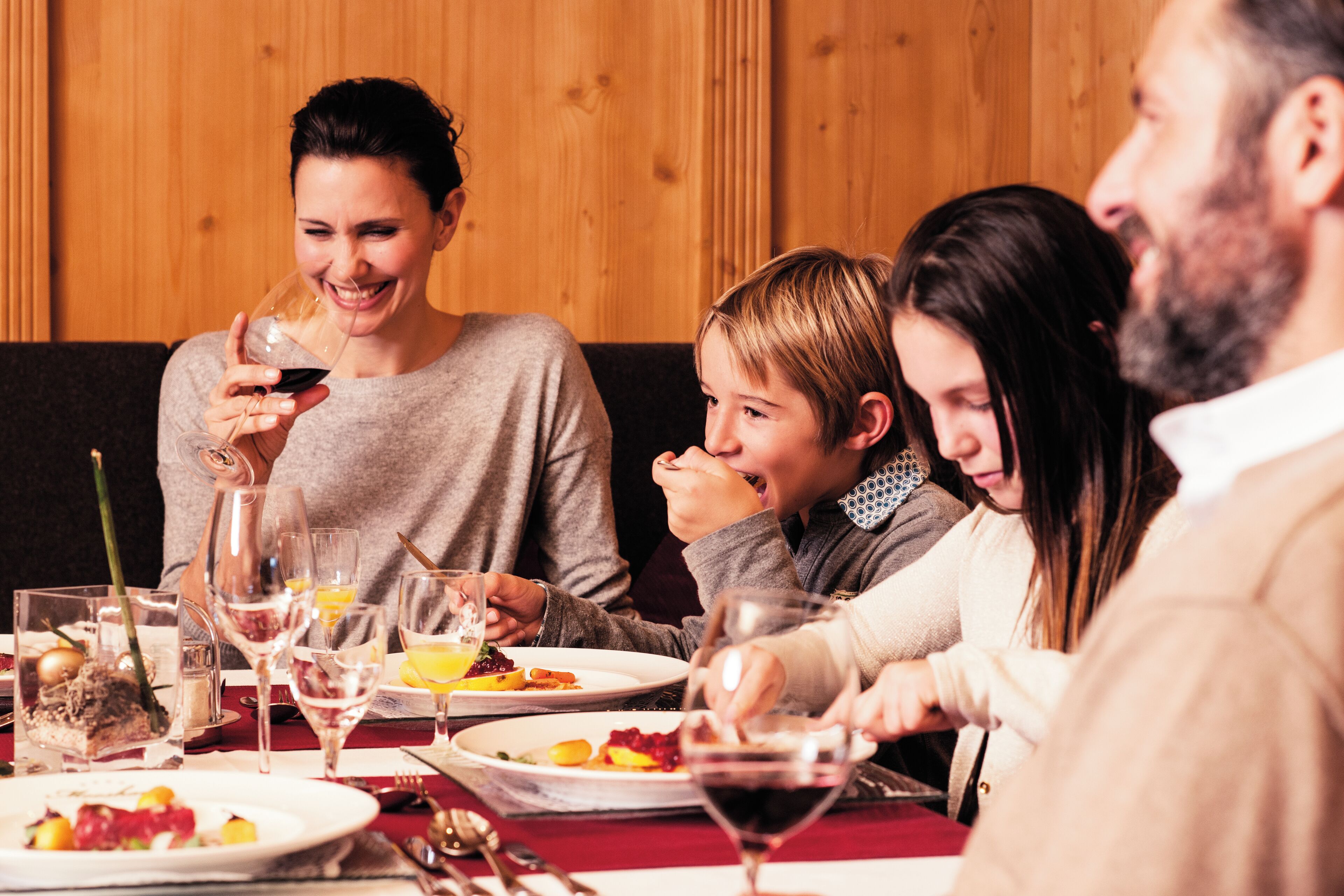 A group of people dining at a table with various dishes and drinks.