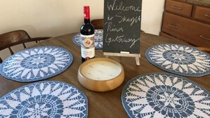 Una mesa con una botella de vino tinto, una vela y un cartel de pizarra que dice 'Welcome to Skagway River Getaway'.
