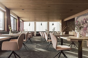 Enjoy meals in this stylish dining area with a long table and comfortable chairs, surrounded by large windows and pendant lights.