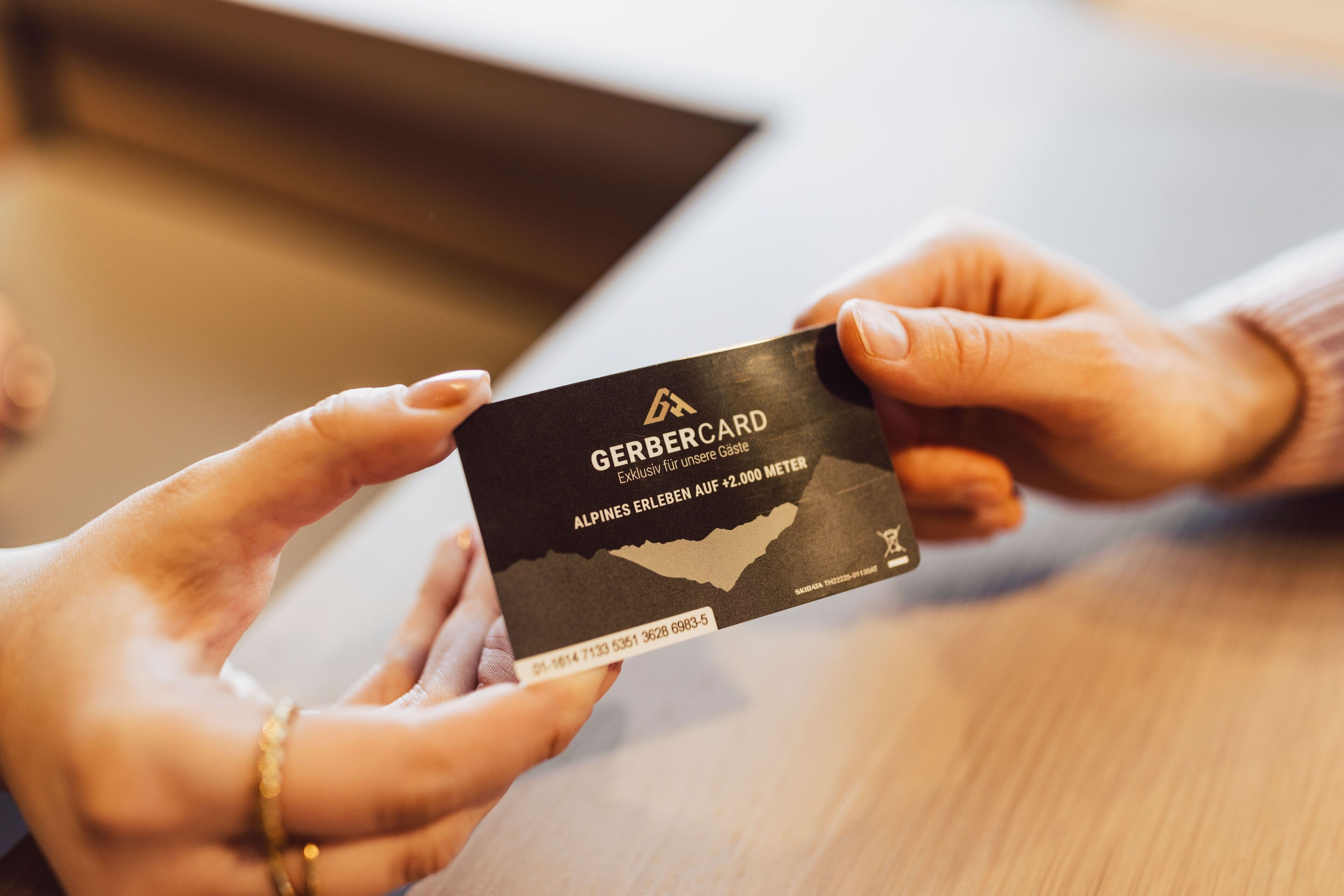 Two hands exchanging a black card with text and a map outline.